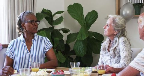 Senior Friends Sharing Breakfast and Engaged Conversation at Home