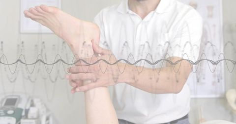 Clinician holding patient foot during mobility assessment with biofeedback waveform overlay