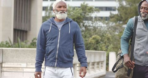 Senior African American Men Walking Together in Urban Park Wearing Hoodies