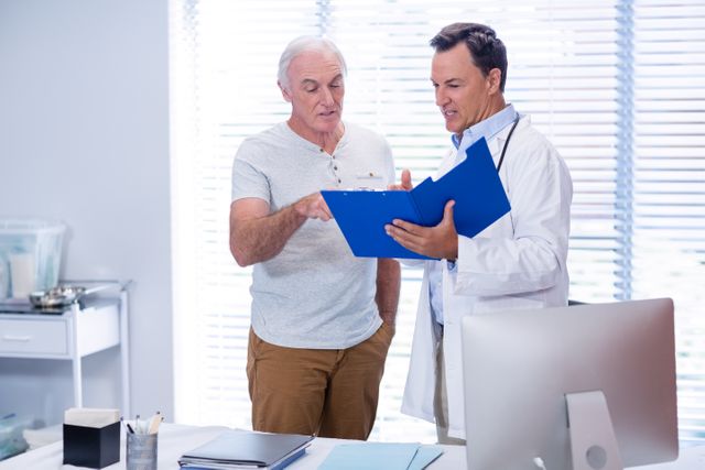 Doctor and senior man discussing on file in clinic
