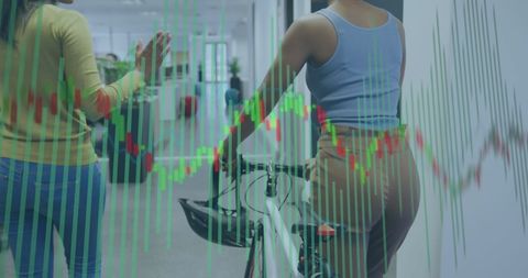 Businesswomen Analyzing Financial Charts in Modern Office