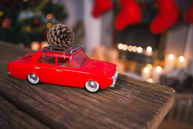 Toy car with pine cone on wooden table during christmas time