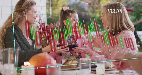 Family Sharing Smartphone at Holiday Table with Stock Market Candlestick Chart Overlay