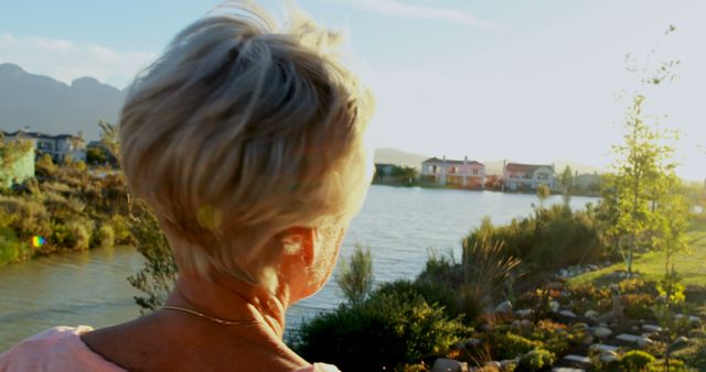 Senior Woman Enjoying Sunrise by Tranquil Lakeside - Download Free Stock Images Pikwizard.com