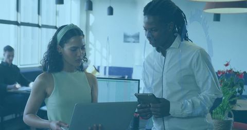 Coworkers Collaborating with Technology in Modern Office