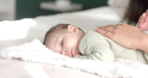 Mother with Baby on Bed, Nurturing and Comforting Scene