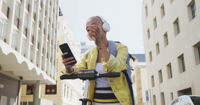 Young woman riding electric scooter while listening to music in city - Download Free Stock Images Pikwizard.com