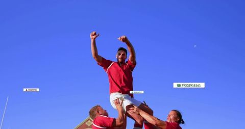 Rugby players lifting teammate in lineout under clear blue sky, teamwork and athleticism