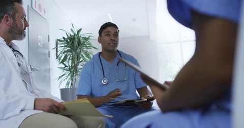 Medical Team Discussing Patient Care in Hospital Corridor During Clinical Handover