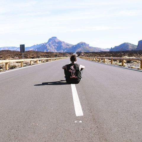 Lone Traveler Enjoying Open Road On Scenic Landscape