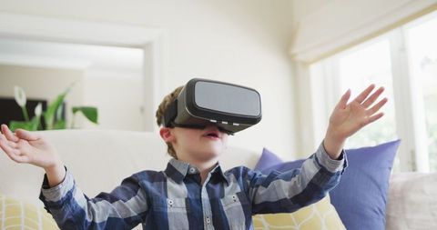 Young boy experiencing virtual reality at home joyfully