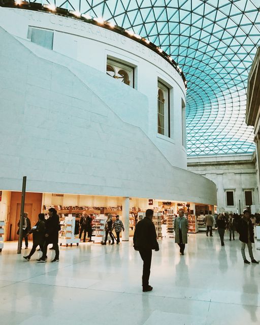 This depicts the interior of a public building featuring a futuristic glass roof structure. People are strolling and exploring, creating a bustling atmosphere. Ideal for use in articles or websites discussing architecture, public spaces, and tourism.