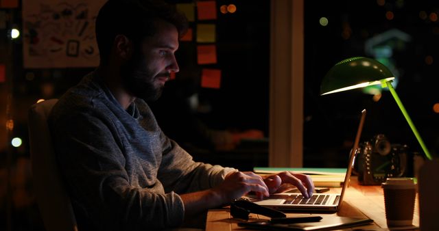 Young Professional Working Late in Dimly Lit Office on Laptop - Download Free Stock Images Pikwizard.com