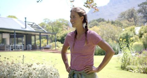 Smiling Woman with Braided Hair Relaxing in Lush Garden