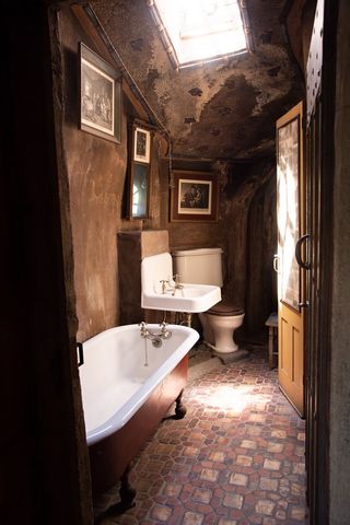 Vintage rustic bathroom with clawfoot bathtub and skylight