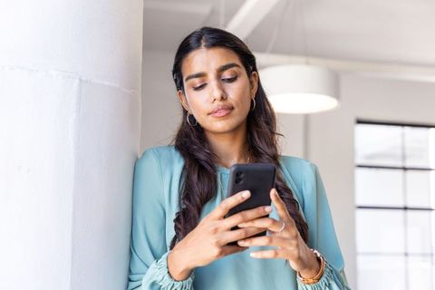 Professional Businesswoman Sending Message on Smartphone in Office