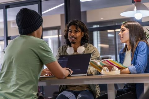 Young adults collaborating on german grammar in modern coworking study space
