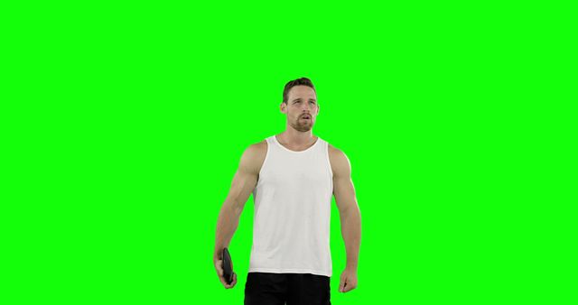 Muscular man wearing white tank top and holding a tablet with a blank green screen background. Perfect for creating advertising materials, fitness tutorials, tech-related presentations, or any project requiring an isolated background for customized content.