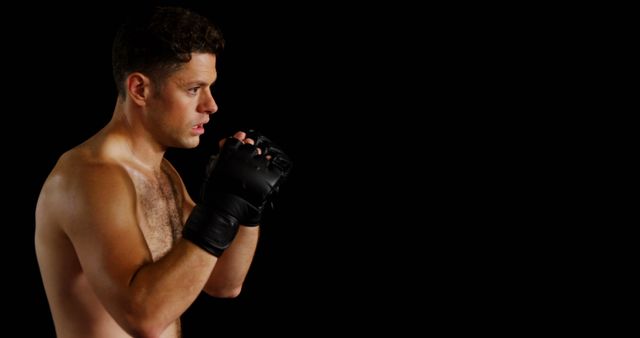 Serious Boxer with Black Gloves in Fighting Stance on Black Background - Download Free Stock Images Pikwizard.com