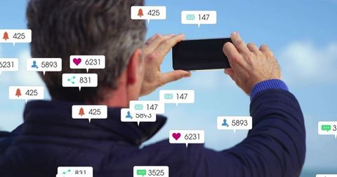 Man capturing coastal horizon on smartphone with floating social media notifications