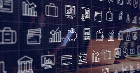 Business analyst viewing financial data on laptop with holographic finance icons overlay