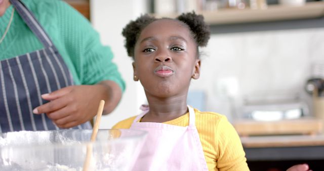 Young girl baking in kitchen wearing apron and green striped shirt - Download Free Stock Images Pikwizard.com