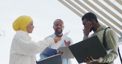 Diverse Business Team Collaborating Outdoors on Project
