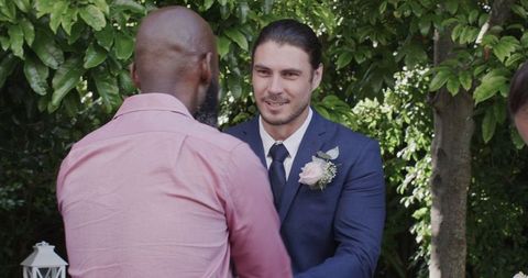 Joyous outdoor wedding ceremony with smiling groom