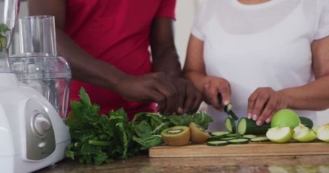 Couple Preparing Fresh Fruit and Vegetable Smoothie at Home