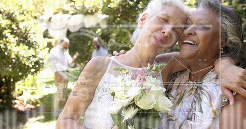 Embracing mature wedding couple pressing heads under garden arch holding bouquet
