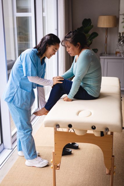 Smiling asian female physiotherapist treating knee of senior female patient. senior healthcare and medical physiotherapy treatment.
