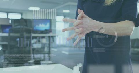 Businesswoman Washing Hands with Data Overlay in Office