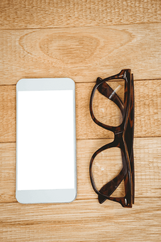 transparent smartphone screen and glasses on wooden desk - Download Free Stock Videos Pikwizard.com