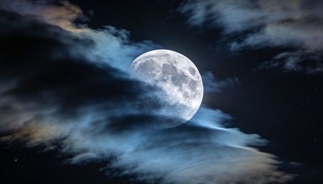 Full Moon Emerging Through Wispy Clouds Over Starry Night Sky, Dramatic Lunar Scene