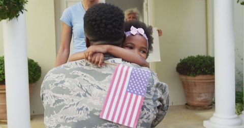 Homecoming Soldier Embraced by Family with American Flag