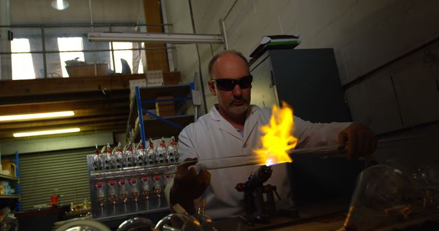 Scientist wearing protective glasses working with an open flame in a laboratory. This image can be used in articles, presentations, and websites related to scientific research, laboratory safety, experiments, and professional scientific practices.