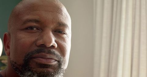 Senior man reflecting near window with soft natural light