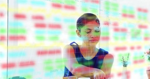Female analyst leaning forward interacting with data dashboard overlay business analytics