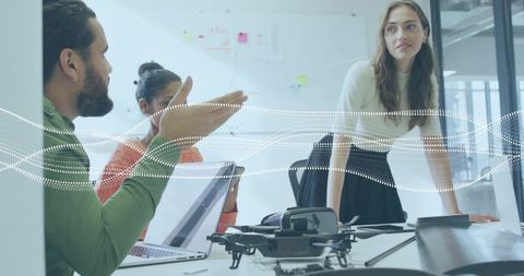 Professionals Collaborating on Drone Design in Tech Workspace