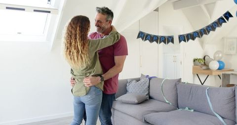 Joyful Mature Couple Dancing in Birthday Decorated Living Room