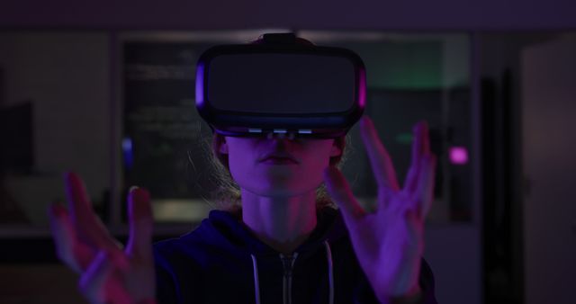 Woman immersing in a virtual reality experience using a VR headset with a glowing neon effect in the background. Useful for content relating to technology, VR gaming, futuristic experiences, and digital innovation. Perfect for articles, blogs, social media, and marketing related to advanced technology and entertainment.
