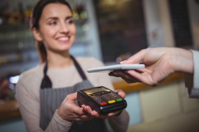 Woman paying bill through smartphone using NFC technology - Download Free Stock Photos Pikwizard.com