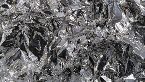 Crumpled reflective foil texture mirrored facets high-contrast metallic wrinkles shiny