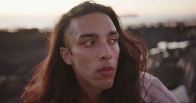 Young Man with Long Hair Reflecting Outdoors at Sunset - Download Free Stock Images Pikwizard.com