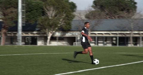 Athlete Dribbling Soccer Ball on Athletic Field Focused Training