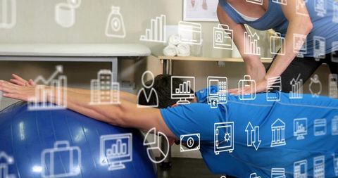 Trainer guiding client stretching on stability ball in rehab clinic with data overlays