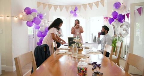Family Setting Up Delightful Birthday Party with Decorations