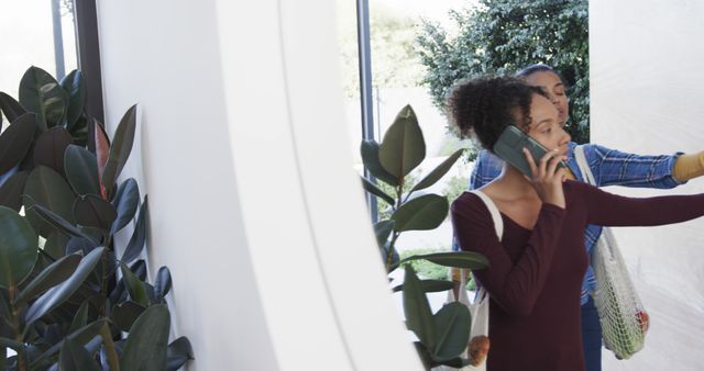 Young Women Entering House, Woman Talking on Phone and Opening Door - Download Free Stock Images Pikwizard.com