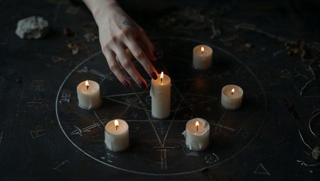 Mystical pentagram candle ritual with hand in focus