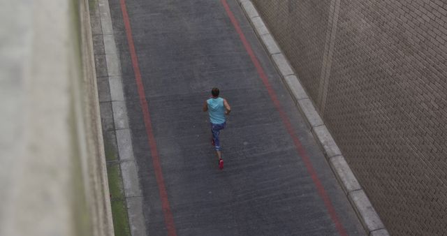 Man Running on Urban Road Surrounded by Brick Walls - Download Free Stock Images Pikwizard.com